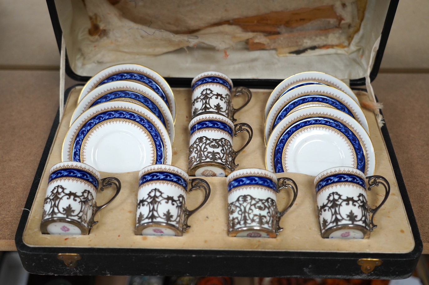 A cased Worcester coffee set with silver coffee can holders, saucers 11.5cm in diameter. Condition - fair, some cracks and crazing